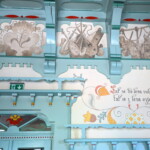 Dekor s příslovím v levé části, nad ním část emblémů řemesel a znak Pohorské jednoty Radhošť