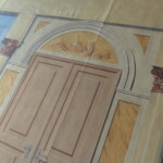 Detail zadního prospektu v průběhu malby. V tympanonu nade dveřmi pohled na gorzanowský zámek