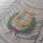 Střed opony zdobí lyra s vavřínovým věncem