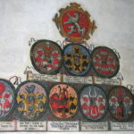 Na stěnách i klenbě byly erby řazeny ve skupinách po devícti - pod královským lvem je vždy trojice erbů vyšších a pak šestice nižších úředníků