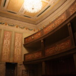 Hlediště zámeckého divadla s balkóny, nástěnnou malbou a novodobým lustrem