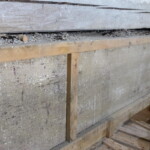 Rub jevištního portálu a harlekýna s vrstvami staletého prachu a ptačího trusu