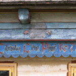 Prkno pod podstávkou s nápisem upomínajícím na postavení původního domu. Stav před restaurováním